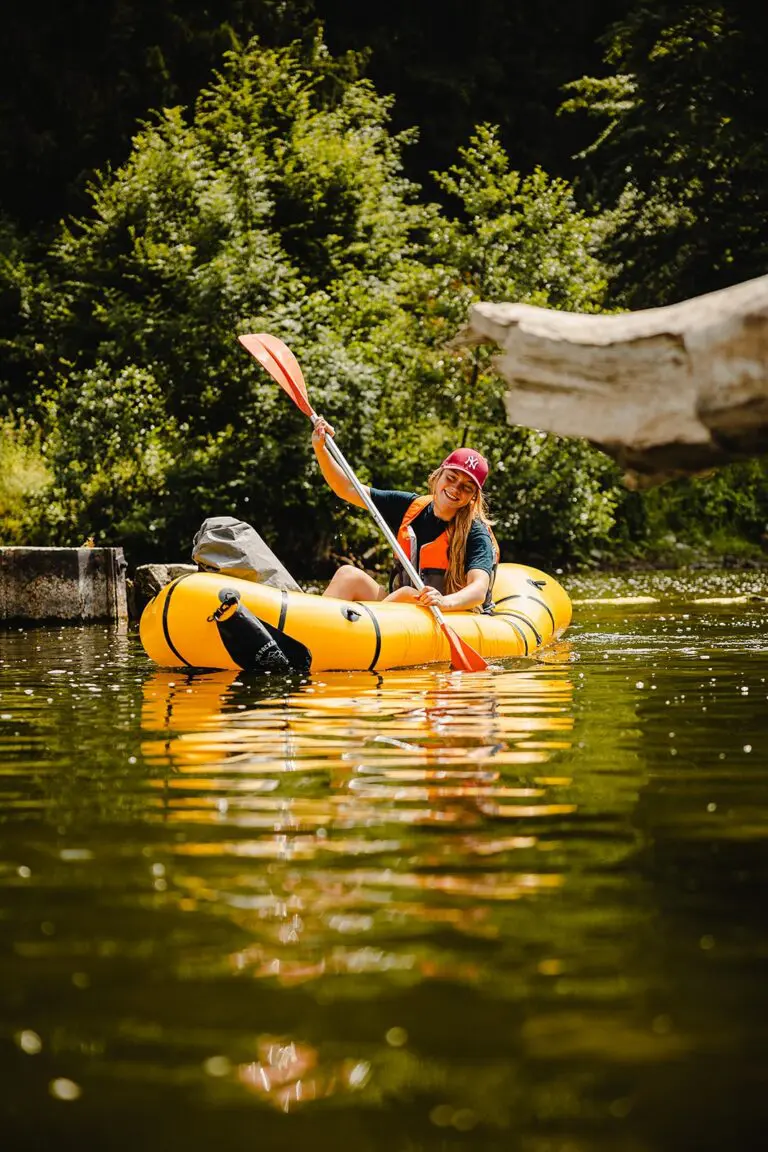 lachende vrouw die aan het packraften is op een rivier in het bos van Semoy