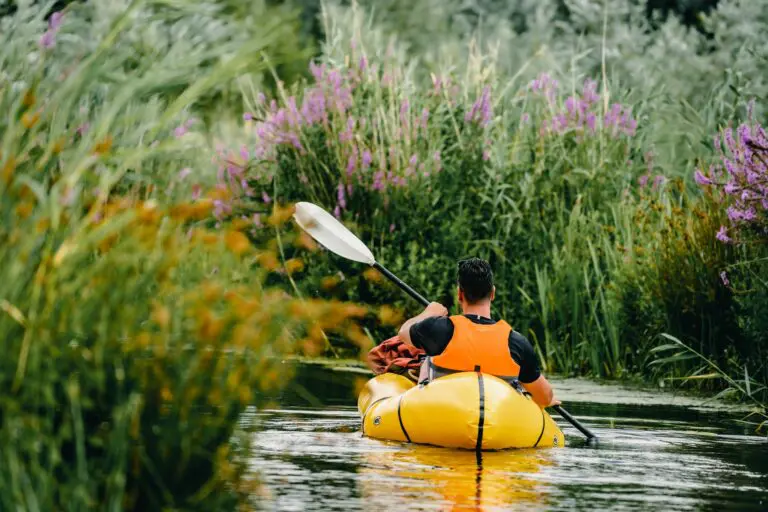 personne pagayant sur la rivière à bord d’un packraft jaune dans la nature du Biesbosch