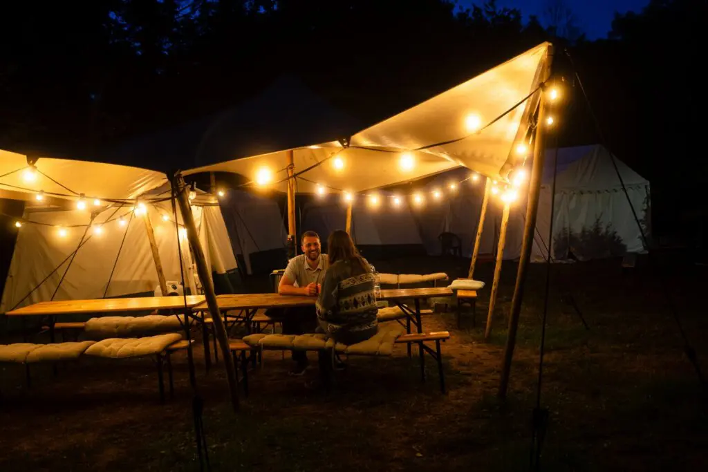 stel dat onder lichtslingers dineert op een glampingcamping