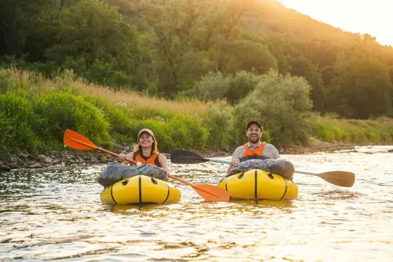 zwei Menschen beim Packrafting auf einem Fluss bei Sonnenuntergang im Müllerthal