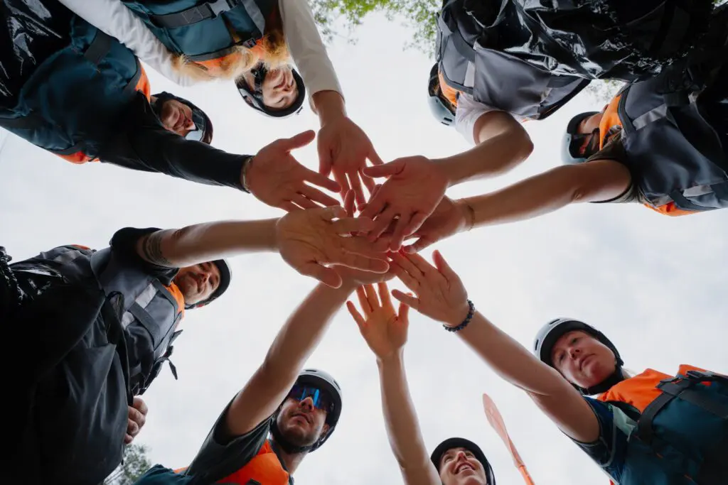 group of people in life vests doing a team huddle
