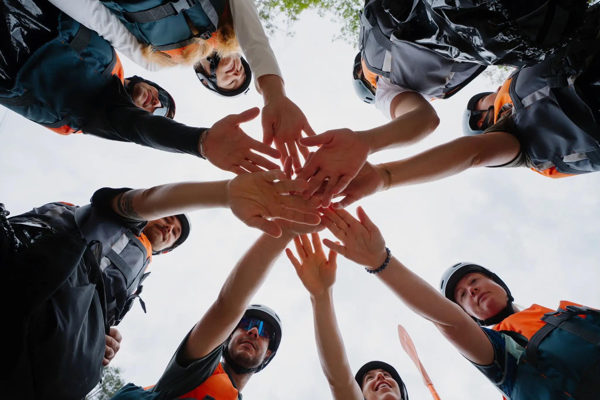 group of people in life vests doing a team huddle